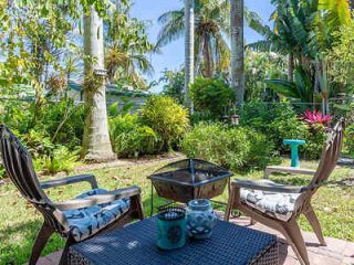 Cozy garden patio with wicker chairs and tropical plants