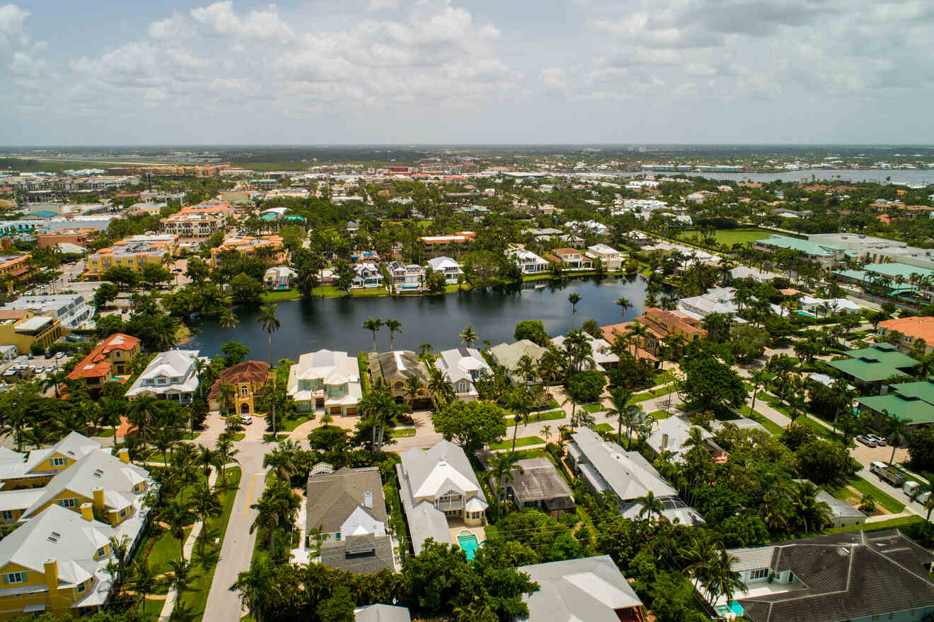 Aerial view of a coastal neighborhood with waterfront homes featuring private docks and boats, interspersed with lush greenery and interconnected waterways