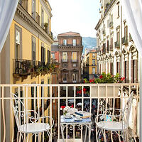 A balcony with a table and chairs overlooking a city.