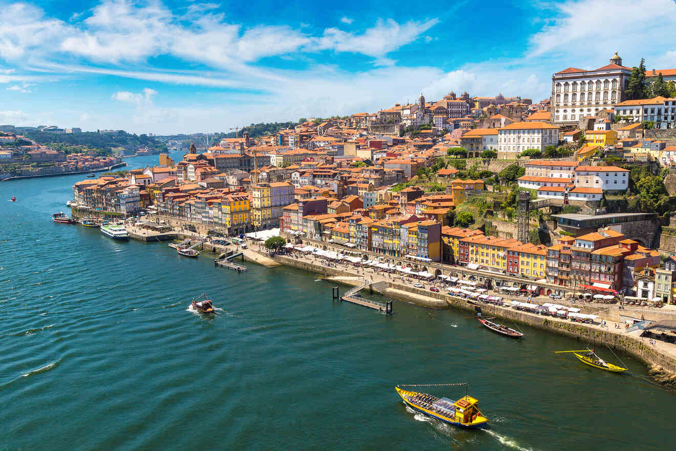 Aerial view of Porto, Portugal, with the Douro River meandering through the city, flanked by colorful traditional houses and boats cruising along the water