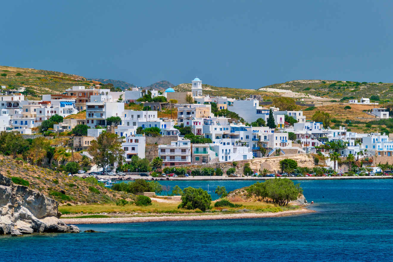 A scenic view of the coastal Greek village Milos with white buildings and a clear blue sky.