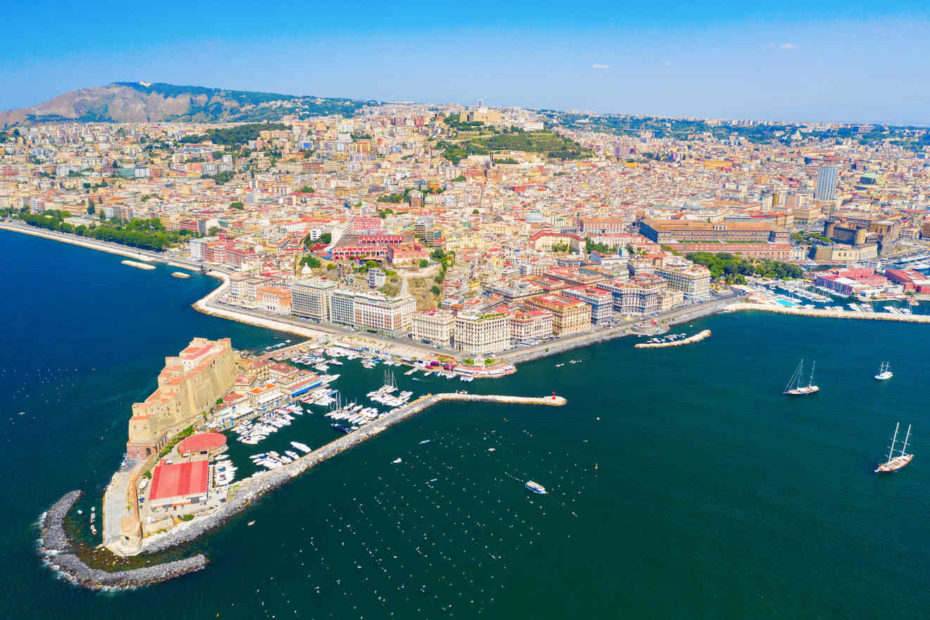 An aerial view of a city with boats docked in the Naples harbor.