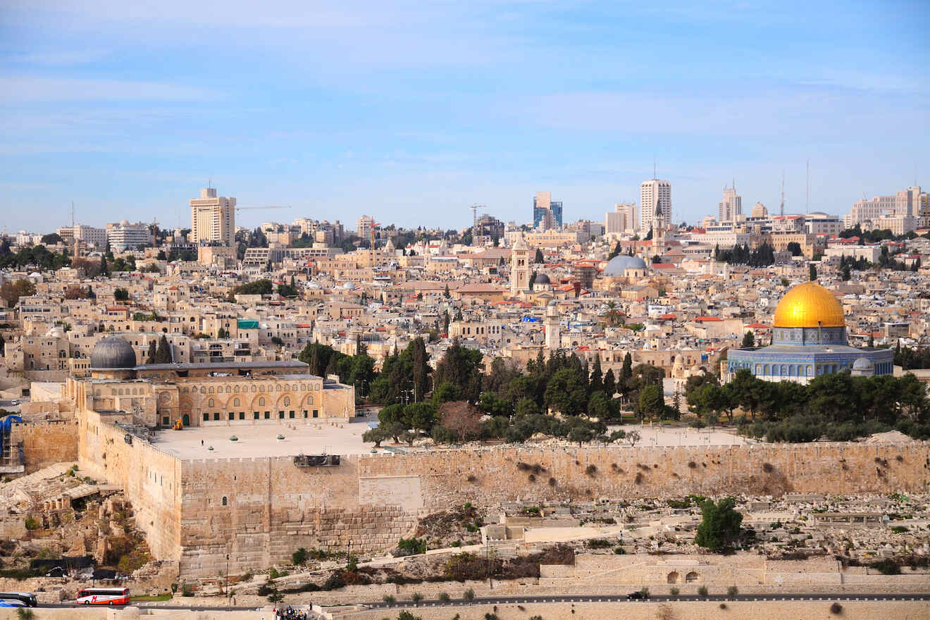 Panoramic view of Jerusalem with the Dome of the Rock in the foreground and modern cityscape in the background.
