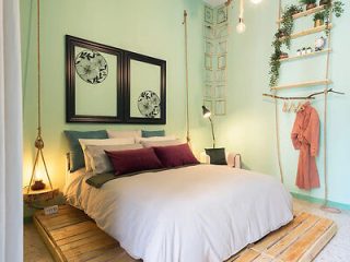 A bedroom with green walls and a bed.