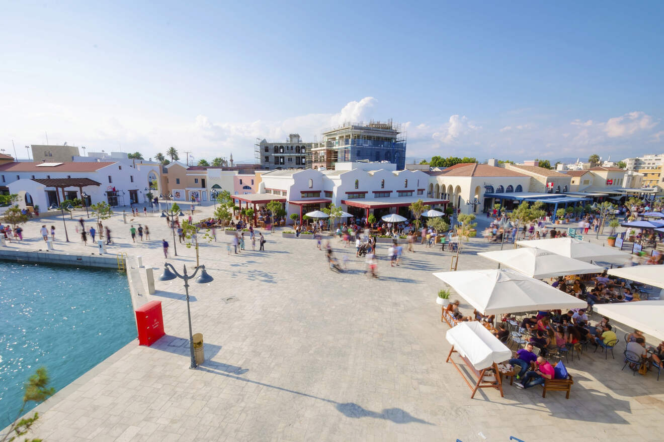 Lively town square by the sea in Limassol, Cyrpus, with crowded cafes and pedestrians, capturing the essence of a Mediterranean hub of activity