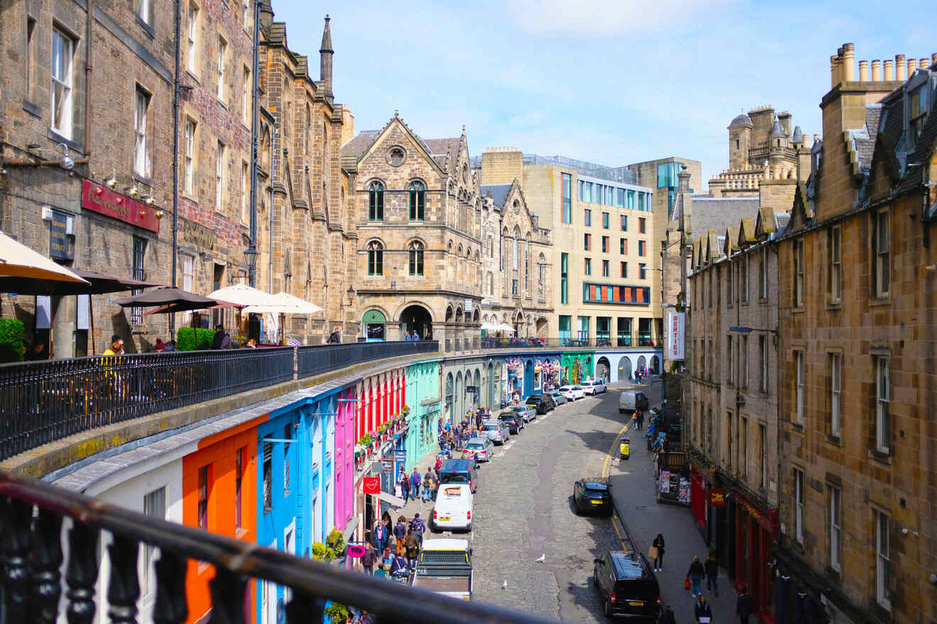 The vibrant and colorful facades of Victoria Street in Edinburgh, bustling with pedestrians and street-side dining, showcasing the city's historic architecture