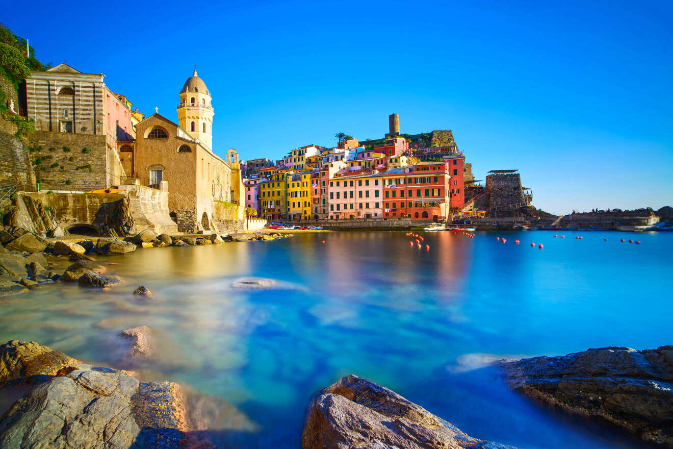 Stunning long exposure shot of Vernazza in Cinque Terre during twilight, with smooth water surfaces and colorful houses creating a magical atmosphere