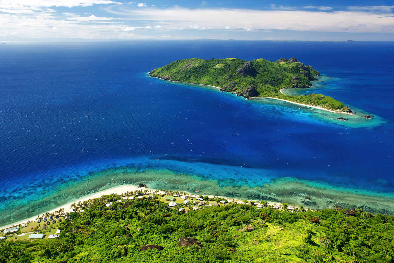 An aerial view of a verdant island with a vibrant reef in the azure sea, capturing the pristine beauty of a tropical paradise