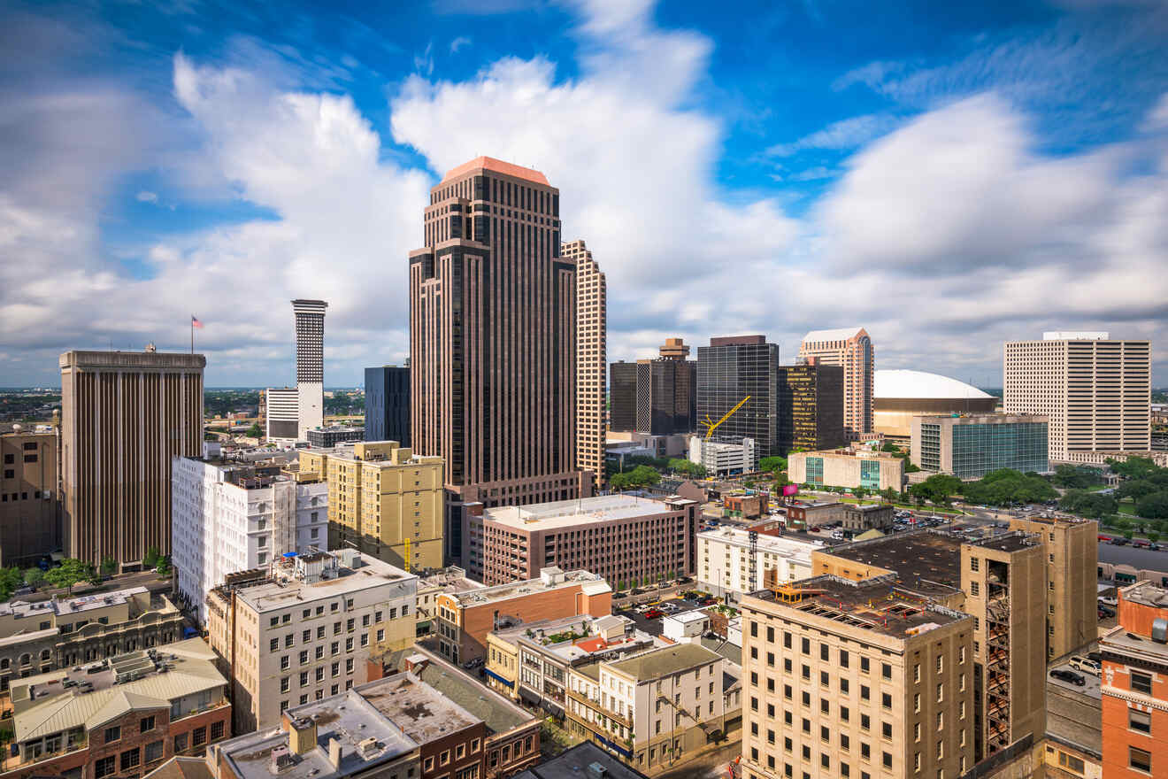 Skyline of a city with a mix of modern high-rise buildings and older structures under a partly cloudy blue sky.