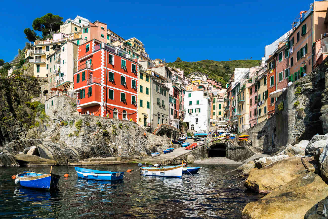 Charming Cinque Terre harbor with bright blue boats and vibrant buildings reflecting the quintessential Italian coastal lifestyle