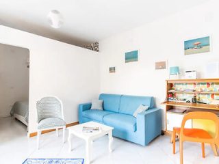 A living room with a blue couch and a white table.