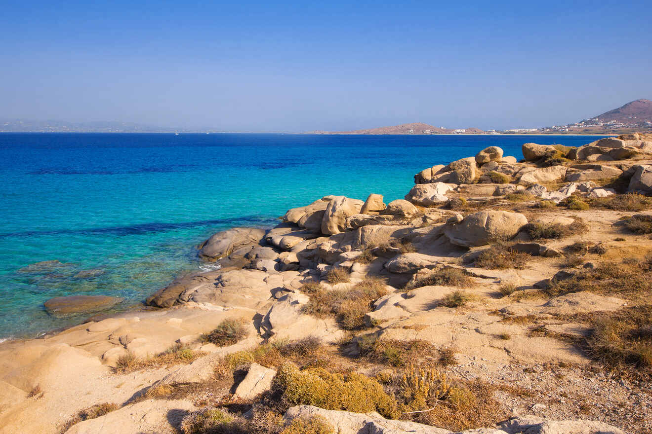 A rocky coastline with clear turquoise waters under a clear blue sky.