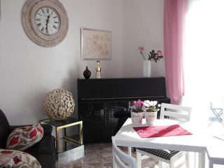 A small living room with a clock on the wall.