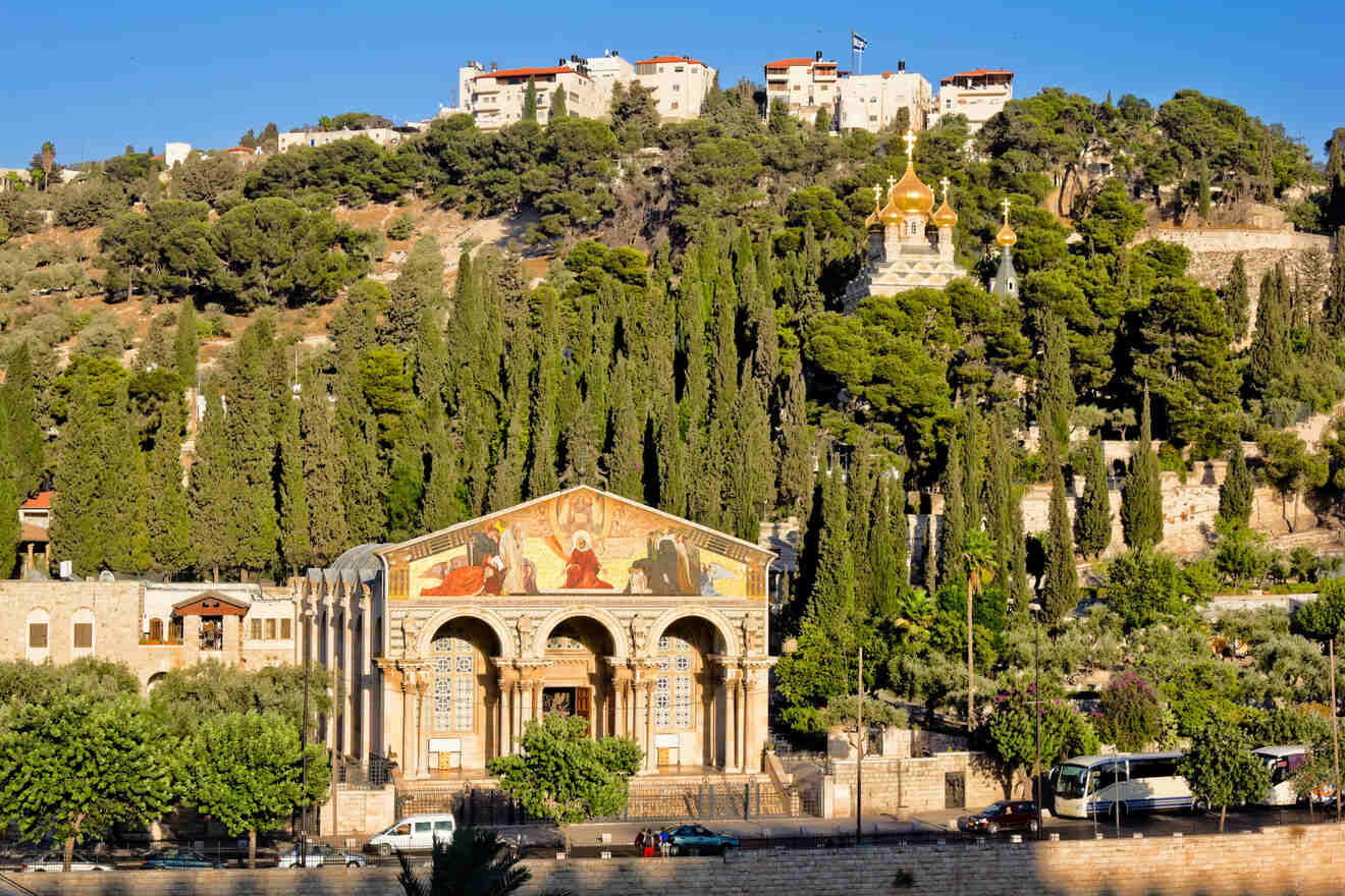 View of the Church of All Nations, also known as the Basilica of the Agony, with its colorful facade and golden domes, set against the Mount of Olives.
