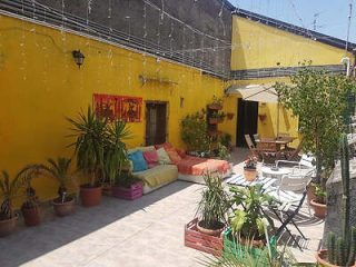 A yellow house with a patio and potted plants.