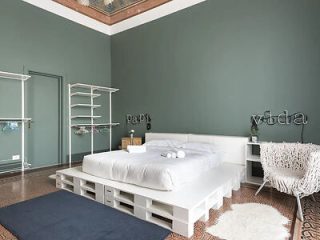 A bedroom with green walls and a white bed.