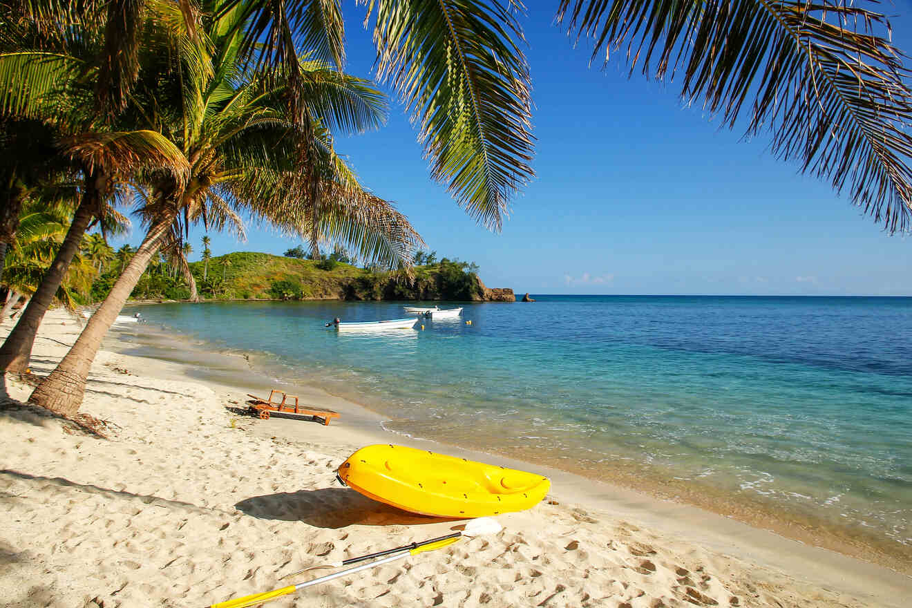 A serene beach scene with a yellow kayak on the shore, palm trees, and calm blue waters, evoking a sense of peaceful island life