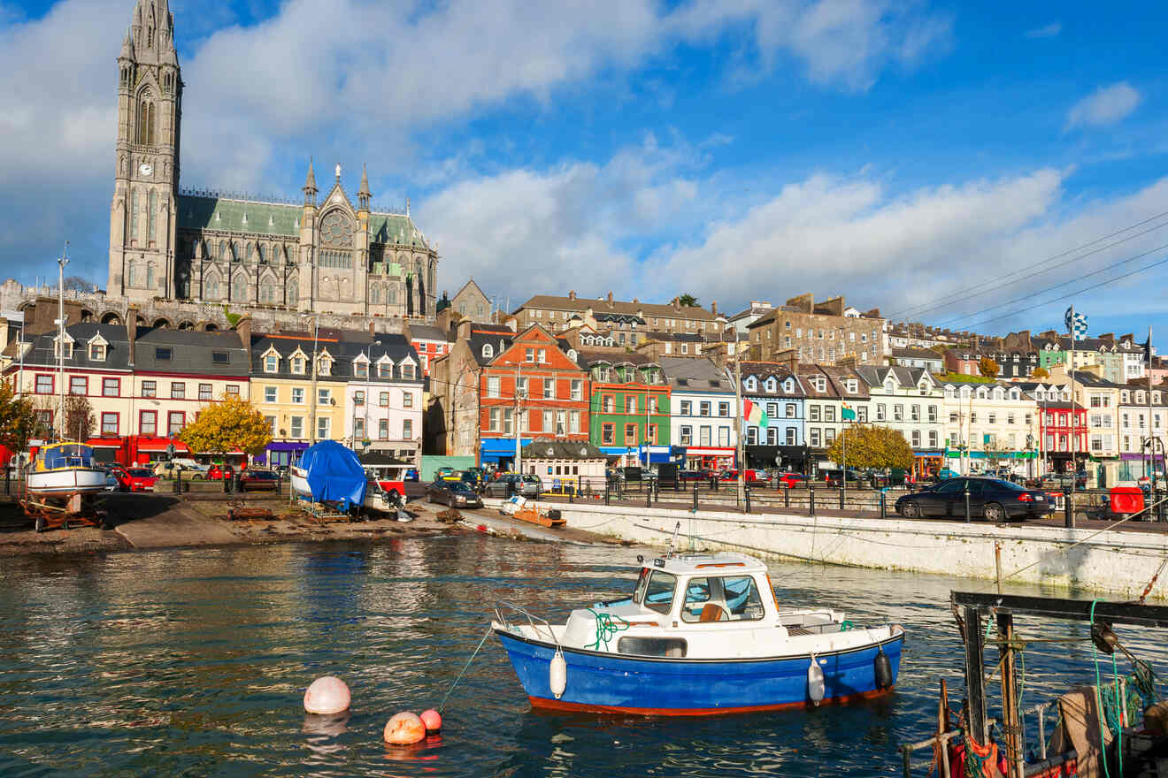 A vibrant harbor scene in Cork, Ireland with colorful houses, boats, and a cathedral in the background under a blue sky