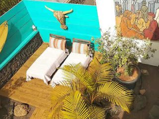 Terrace with beds, colorful cushions, and cultural wall art