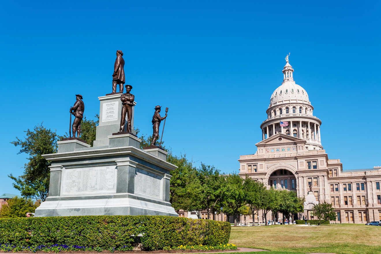 Texas state capitol building with statues in front of it located in Downtown Austin