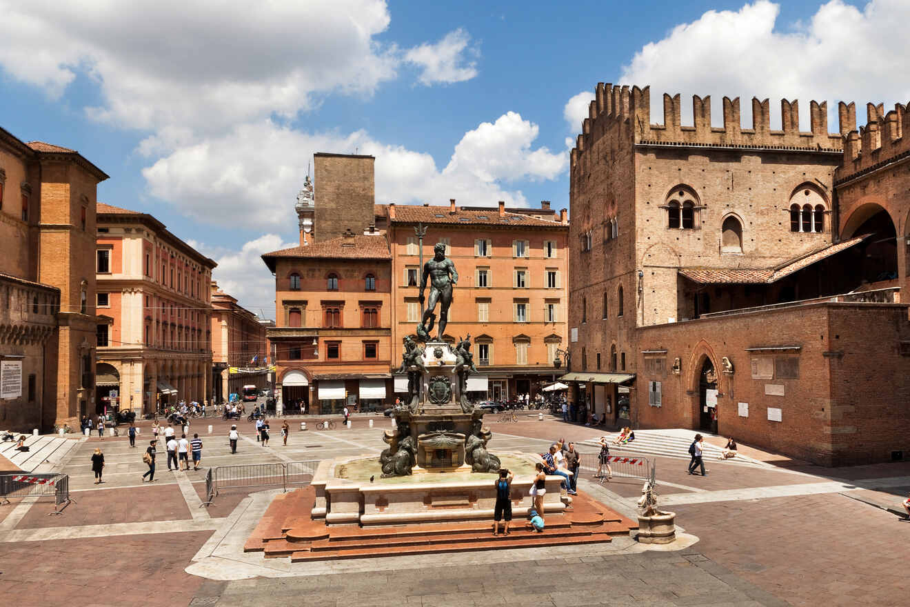 Bustling Piazza Maggiore in Bologna with the Neptune Fountain, historic buildings, and visitors enjoying the sunny square.
