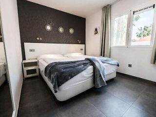 Stylish bedroom with dark accent wall and modern decor.