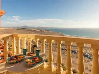 Balcony view with breakfast overlooking the sea.