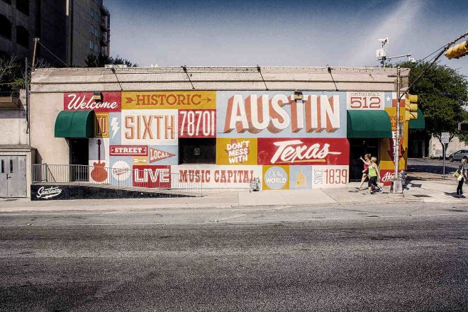 a building with street graffiti of words on the side of it located in East Austin
