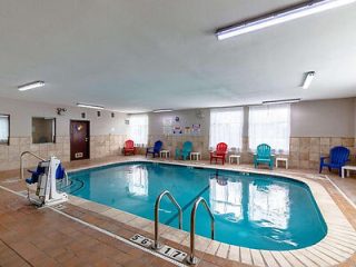 an indoor hotel pool with chairs around it