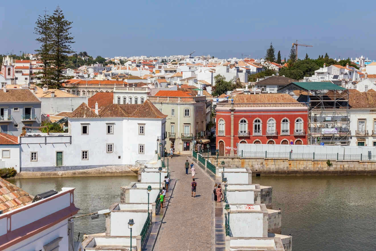 Historical town center with a bridge leading to a street lined with traditional European buildings, and a river running through it