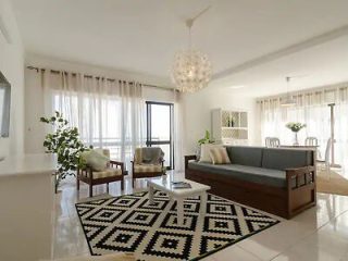 Spacious living room with contemporary decor, a geometric patterned rug, and large windows