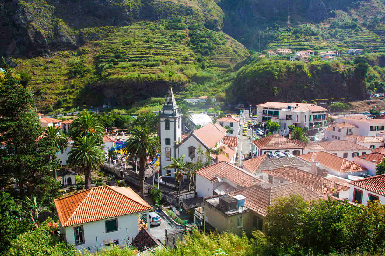 A picturesque village nestled in a lush valley, with traditional architecture, a prominent church tower, and terraced agriculture on the slopes