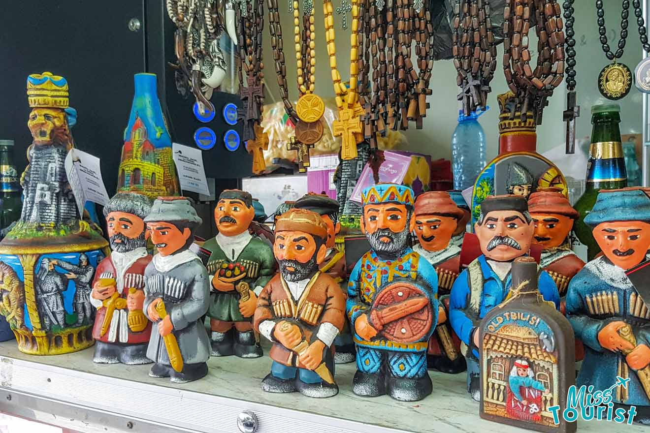 Colorful Georgian souvenirs displayed on a market stall, including traditional figurines and cultural crafts, showcasing the vibrancy of local artisan work.