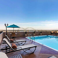 Hotel rooftop pool with lounge chairs and a view of the Hernando de Soto Bridge