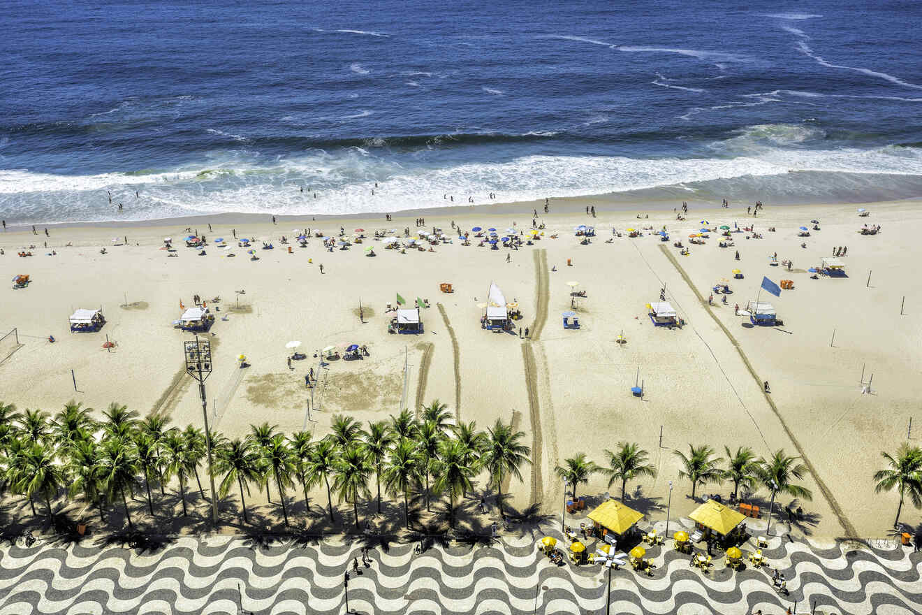 Scenic view of Copacabana Beach in Rio de Janeiro with sunbathers, palm trees, and iconic wavy sidewalk pattern