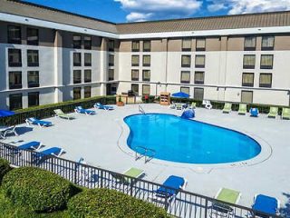 Memphis hotel pool area enclosed by a building, featuring a clean, blue swimming pool and surrounding lounge chairs