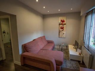 Living area with a blush pink sofa, contemporary artwork, and soft lighting, creating a relaxing ambiance