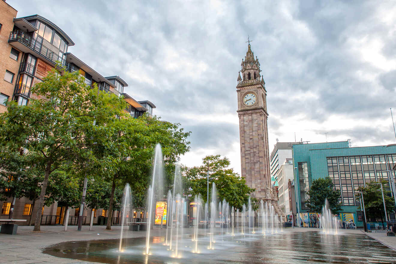 Albert Clock tower in Belfast standing tall amidst the cityscape, with water fountains in the foreground creating a serene urban oasis