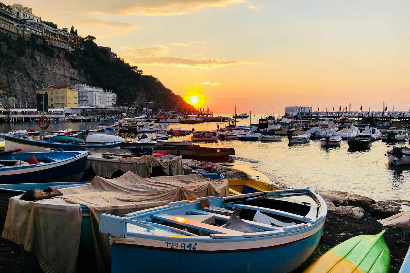 Sunset over Sorrento harbor with moored boats in the foreground and a glowing sky