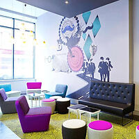 Colorful hotel lobby with modern furniture in vibrant pink and blue, abstract wall art