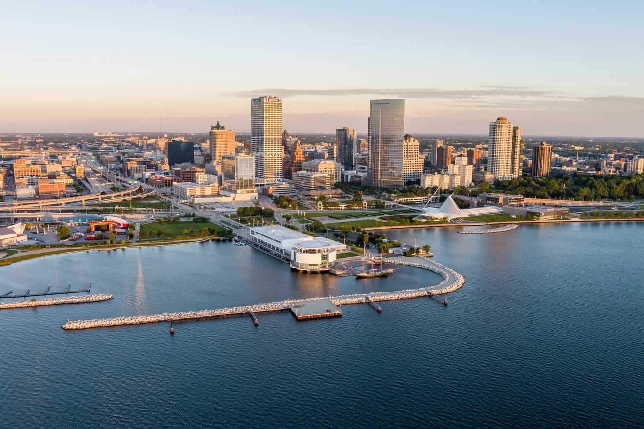 Aerial view of a city skyline in Milwaukee Wisconsin near water with a white modern pavilion on the pier during sunset