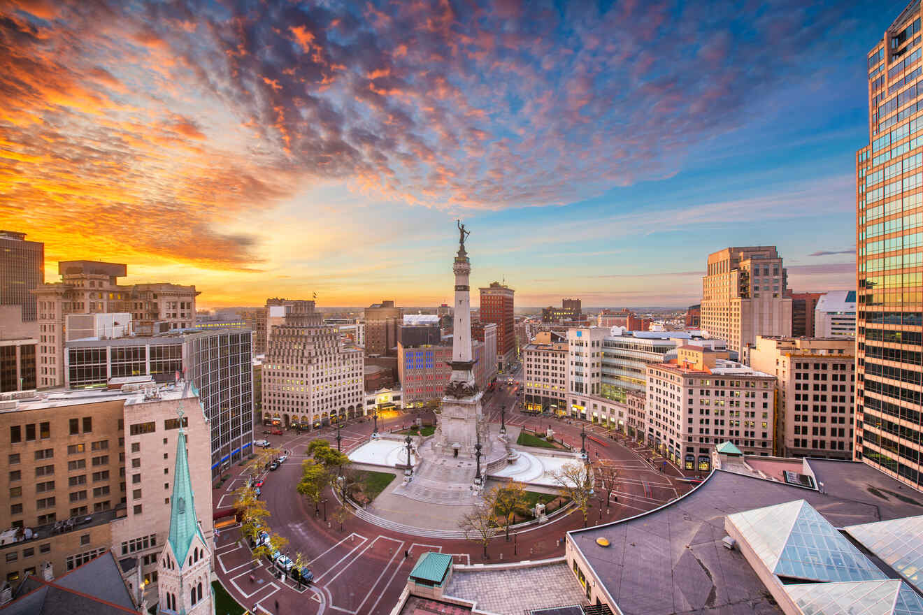 Dramatic sunset over Indianapolis, showcasing the Soldiers and Sailors Monument, bustling city streets, and vibrant sky with scattered clouds