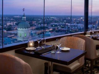 Romantic dinner setting for two with a view, overlooking the Indiana State Capitol building at dusk from a high-rise restaurant
