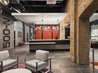 Contemporary hotel lobby with a blend of vintage brickwork and modern design elements