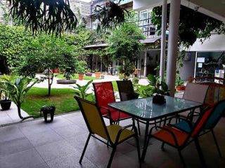 An outdoor seating area with vibrant chairs surrounded by lush greenery.