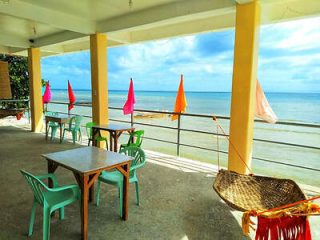 An open dining area overlooking the sea, featuring colorful tables and chairs
