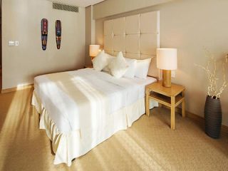 A neatly arranged hotel room with a large bed and two side tables with lamps