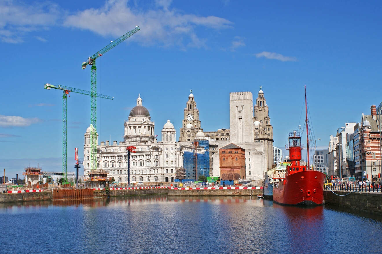 The Liverpool waterfront showing historic architecture, including the Royal Liver Building and modern developments, alongside the calm waters of the River Mersey.