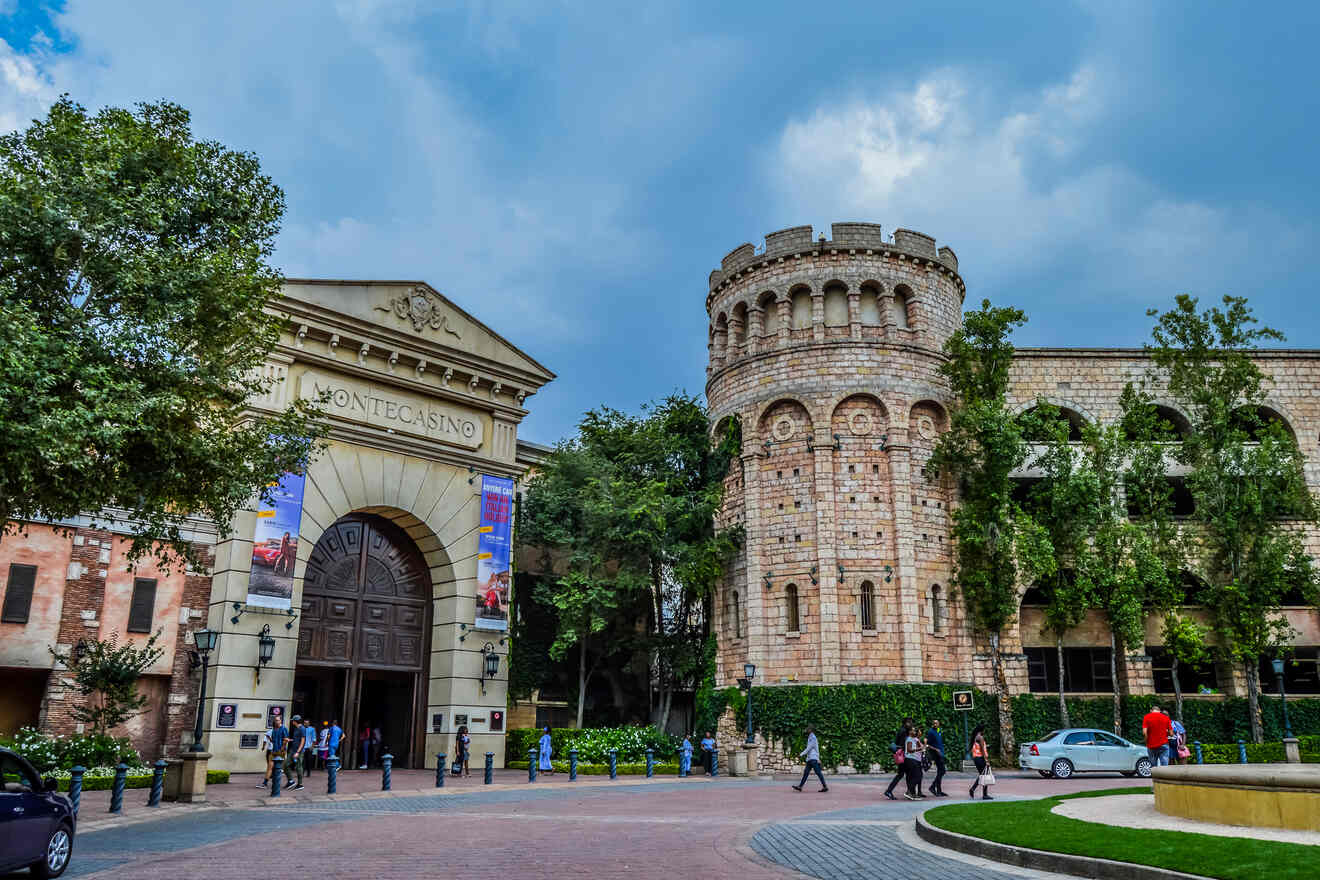 The grand entrance of Montecasino in Johannesburg with a castle-like structure, showcasing people walking and lush greenery around