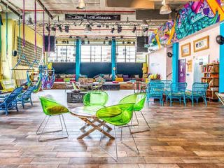 An eclectic, colorful interior with artistic decorations, vibrant chairs, and a playful atmosphere.